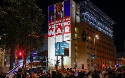 Un panneau appelant à la fin de la guerre entre Israël et le Hamas ainsi qu'un portrait du président élu américain Donald Trump au sommet d'un bâtiment près d'une manifestation d'Israéliens de droite rejetant un accord potentiel avec le Hamas, à Jérusalem, le 13 janvier 2025. (Crédit : Menahem Kahana/AFP)