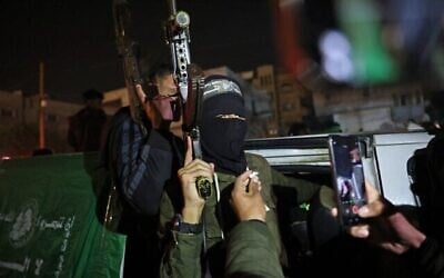 Des membres des Brigades Ezzedine al-Qassam du Hamas arrivant dans un véhicule dans une rue de Khan Younès, dans le sud de la bande de Gaza, le 15 janvier 2025, après avoir appris l'imminence d'un accord de cessez-le-feu et de libération d'otages. (Crédit : Bashar Taleb/AFP)