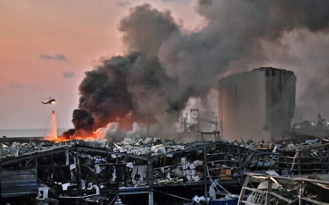(FILES) Un hélicoptère éteint un incendie sur les lieux d'une explosion au port de Beyrouth, la capitale du Liban, le 4 août 2020. (Photo par AFP)