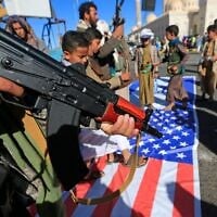 Un manifestant tenant un fusil lors d'un rassemblement pour dénoncer Israël et en solidarité avec les Palestiniens dans la capitale Sanaa, contrôlée par les Houthis, le 17 janvier 2025. (Crédit : Mohammed Huwais/AFP)