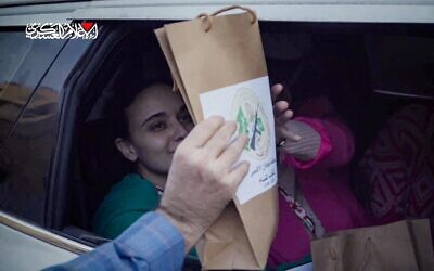 Cette image issue d'une vidéo diffusée par le groupe terroriste Hamas montre les otages israéliennes Emily Damari (à gauche) et Romi Gonen recevant un sac portant le logo de la branche armée du Hamas, alors qu'elles sont assises dans un véhicule du Hamas avant d'être remises au Comité international de la Croix-Rouge dans la bande de Gaza, le 19 janvier 2025. (Capture d'écran : Hamas/AFP)