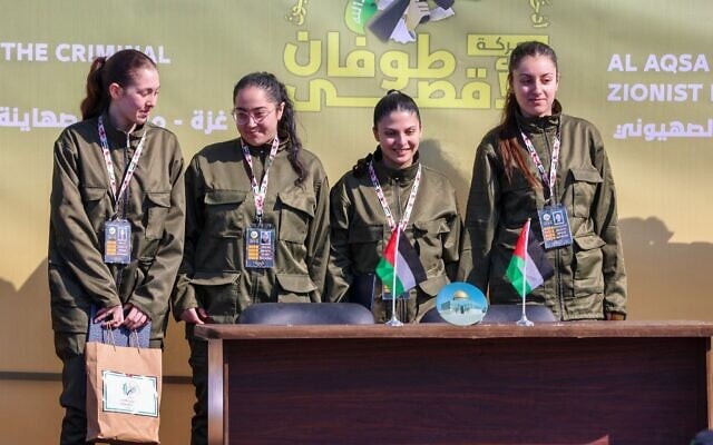 Les otages israéliennes Liri Albag, Karina Ariev, Daniella Gilboa, Naama Levy saluant sur une scène avant que des terroristes du Hamas ne les remettent à une équipe de la Croix-Rouge, dans la ville de Gaza, le 25 janvier 2025. (Crédit : John Wessels/AFP) Les otages israéliennes Liri Albag, Karina Ariev, Daniella Gilboa, Naama Levy saluant sur une scène avant que des terroristes du Hamas ne les remettent à une équipe de la Croix-Rouge, dans la ville de Gaza, le 25 janvier 2025. (Crédit : John Wessels/AFP)