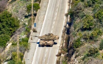 Un char de combat de l'armée israélienne se déplaçant sur une route à l'entrée du village de Hula, le long de la frontière avec Israël, sur une photo prise dans le village de Chaqra, au sud du Liban, le 25 janvier 2025. (Crédit : AFP)