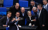 Des membres du parti d'extrême droite Alternative pour l'Allemagne (AfD), dont les codirigeants de l'AfD Alice Weidel (3eD) et Tino Chrupalla (2eL), se prennent en photo avec un téléphone portable alors qu'ils se réjouissent après un vote lors d'une session au Bundestag, la chambre basse du parlement, le 29 janvier 2025 à Berlin. (Crédit : John MACDOUGALL / AFP)