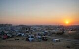 Le soleil se couche sur un camp de tentes pour les Palestiniens déplacés dans la ville de Khan Younès, au centre de la bande de Gaza, le 1er janvier 2025. (Crédit : AP Photo/ Abdel Kareem Hana)