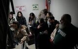 Des Israéliens rassemblés dans un abri après que les sirènes d'une frappe aérienne ont retenti près de Tel Aviv, le 3 janvier 2024. (Crédit : AP/Matias Delacroix)