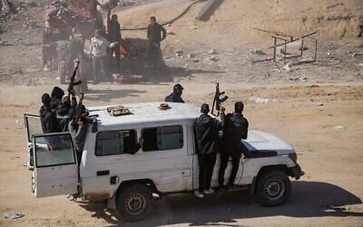 Des hommes armés du Hamas escortent les camions d'aide humanitaire qui entrent dans la bande de Gaza, à Rafah, le 21 janvier 2025, quelques jours après l'entrée en vigueur d'un accord de cessez-le-feu entre le Hamas et Israël. (Crédit : AP/Jehad Alshrafi)