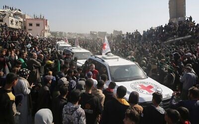 Une foule entourant les voitures de la Croix-Rouge alors qu'elles arrivent sur le site de la remise des otages thaïlandais et israéliens à Khan Younès, dans le sud de la bande de Gaza, le 30 janvier 2025. (Crédit : Jehad Alshrafi/AP)