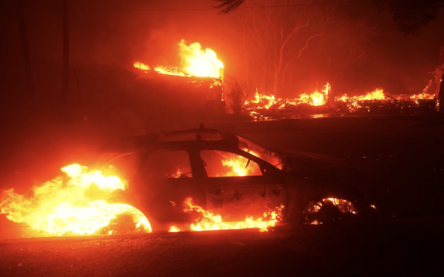 Un véhicule en feu alors que l'incendie de Palisades balaie le quartier de Pacific Palisades, à Los Angeles, le 7 janvier 2025. (Crédit : Etienne Laurent/AP)