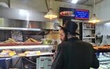 Un client choisissant des tranches chez, Trump Pizza, à Jérusalem, le 20 janvier 2025. (Crédit : Deborah Danan, via JTA)