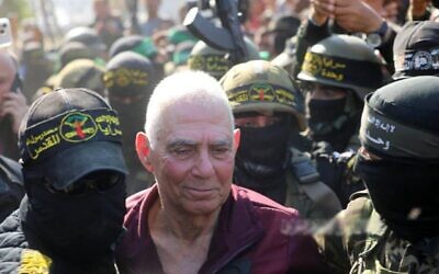 Gadi Mozes, 80 ans, entouré de terroristes armés au moment de sa libération, à Khan Younès, à Gaza, le 30 janvier 2025. (Crédit : Réseaux sociaux)