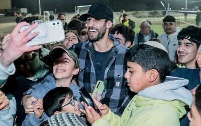 Le chanteur et acteur Idan Amedi, blessé alors qu'il était réserviste à Gaza, se produit dans le camp One Family, pour Hanoukka, devant des enfants touchés par le deuil, le 30 décembre 2024 (Autorisation)
