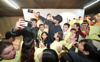 Le chanteur et acteur Idan Amedi, blessé alors qu'il était réserviste à Gaza, se produit dans le camp One Family, pour Hanoukka, devant des enfants touchés par le deuil, le 30 décembre 2024 (Autorisation)