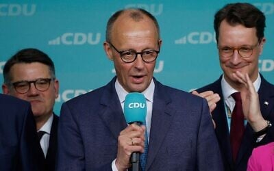 Friedrich Merz, leader de l'Union chrétienne-démocrate (CDU) et principal candidat de son parti au poste de chancelier, s'adresse à ses partisans après l'annonce des premiers sondages de sortie des urnes des élections générales allemandes à la télévision allemande lors de la soirée électorale à Berlin, Allemagne, 23 février 2025. (Crédit : Odd Andersen / AFP)