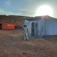 Un astronaute analogique israélien marchant dans une combinaison spatiale simulée à côté d'un rover spatial, dans le Cratère de Ramon, dans le Néguev, le 31 octobre 2021. (Crédit : Amy Spiro)