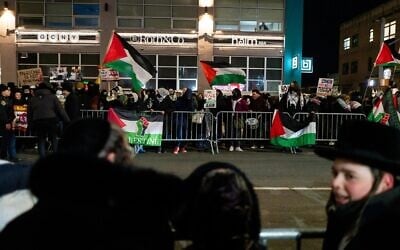 Des résidents juifs de Boro Park, à Brooklyn, regardent des manifestants anti-Israël dans leur quartier, le 18 février 2025. (Crédit : Luke Tress/Times of Israel)