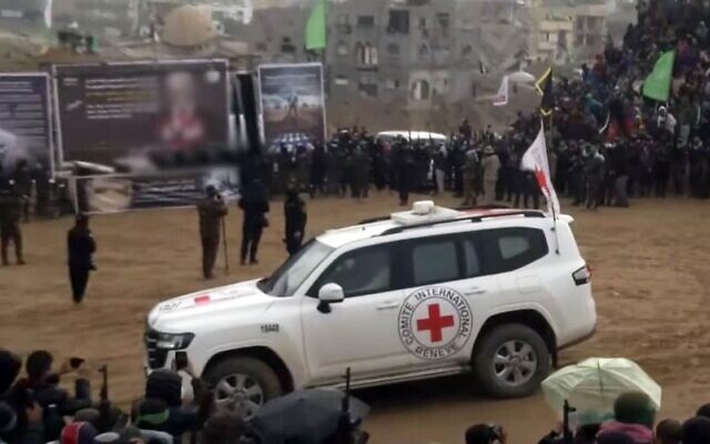 Un véhicule de la Croix-Rouge arrivant avant que le Hamas ne remette les corps de quatre otages israéliens, Shiri Bibas et ses deux jeunes enfants Kfir et Ariel, et Oded Lifshitz, à Khan Younès, dans le sud de la bande de Gaza, le 20 février 2025. À l'arrière-plan, on voit une scène montée par le Hamas avec un message de propagande et quatre cercueils. (Crédit : Capture d'écran/YouTube)