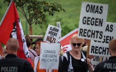 Sur une pancarte, on peut lire « Bjoern Hoecke est un nazi » alors que des membres de l'initiative citoyenne allemande « Omas gegen rechts » manifestent contre le 14e congrès fédéral du parti d'extrême-droite allemand Alternative für Deutschland (AfD) lors de la foire commerciale de Magdebourg, dans l'est de l'Allemagne, le 28 juillet 2023. (Photo de Ronny HARTMANN / AFP)