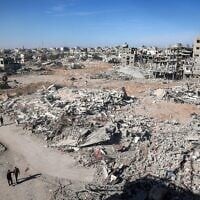 Des Palestiniens marchent devant les décombres dans un quartier en ruine de Rafah, dans le sud de la bande de Gaza, le 21 janvier 2025. (Crédit : Eyad BABA / AFP)