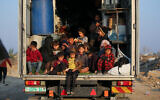 Des enfants palestiniens déplacés sont assis à l'arrière d'un camion alors que les habitants se dirigent du sud vers les parties nord de la bande de Gaza, sur la route Salah al-Din à Nuseirat dans le centre de Gaza, le 29 janvier 2025. (Crédit : Eyad BABA / AFP)