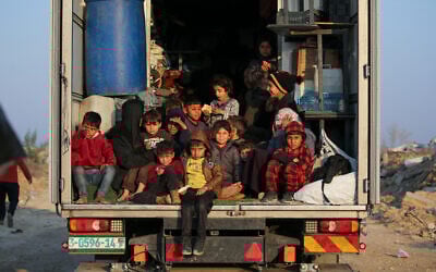 Des enfants palestiniens déplacés sont assis à l'arrière d'un camion alors que les habitants se dirigent du sud vers les parties nord de la bande de Gaza, sur la route Salah al-Din à Nuseirat dans le centre de Gaza, le 29 janvier 2025. (Crédit : Eyad BABA / AFP)