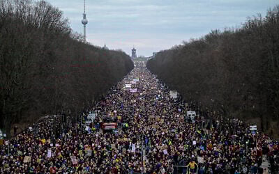 Des manifestants participent à une manifestation sous le slogan « Forts contre les nazis » avec les monuments de la Porte de Brandebourg (au centre), de l'hôtel de ville Rotes Rathaus (au centre, à gauche) et de la tour de télévision (à gauche) en arrière-plan à Berlin le 2 février 2025. (Crédit : John MACDOUGALL / AFP)