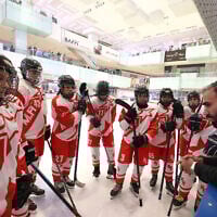 Les joueuses de l'équipe M.R écoutent leur entraîneur lors de leur match de hockey sur glace de la Ligue féminine iranienne contre l'équipe Hockey Panda à la patinoire d'Iran Mall à Téhéran, le 29 janvier 2025. (Crédit : ATTA KENARE / AFP)
