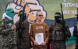 Des terroristes armés du Hamas entourant Ohad Ben Ami sur une scène avant de le remettre à une équipe de la Croix-Rouge, à Deir el-Balah, dans le centre de la bande de Gaza, le 8 février 2025. (Crédit : Eyad Baba/AFP)