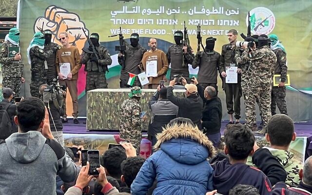 Des terroristes armés du Hamas palestinien faisant défiler les otages israéliens (de gauche à droite) Ohad Ben Ami, Or Levy et Eli Sharabi sur une scène avant de les remettre à une équipe de la Croix-Rouge, à Deir el-Balah, dans le centre de Gaza, le 8 février 2025. (Crédit : Bashar Taleb/AFP) Des terroristes armés du Hamas palestinien faisant défiler les otages israéliens (de gauche à droite) Ohad Ben Ami, Or Levy et Eli Sharabi sur une scène avant de les remettre à une équipe de la Croix-Rouge, à Deir el-Balah, dans le centre de Gaza, le 8 février 2025. (Crédit : Bashar Taleb/AFP)