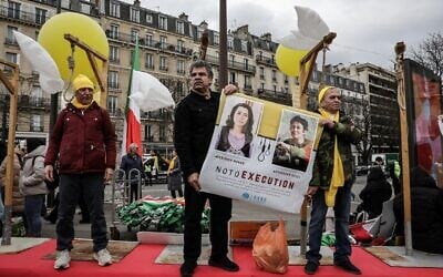 Des personnes simulant une pendaison lors d'une manifestation organisée par un groupe d'opposition iranien à l'occasion du 46ème anniversaire du soulèvement contre le Shah, à Paris, le 8 février 2025. (Crédit : Thibaud Moritz/AFP)