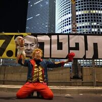 Un manifestant portant un masque de Donald Trump tient une poupée portant un masque de Benjamin Netanyahu lors d'une manifestation appelant à la libération des otages retenus captifs par les terroristes palestiniens à Gaza, devant le QG du ministère de la Défense à Tel Aviv, le 8 février 2025. (Photo par Jack GUEZ / AFP)