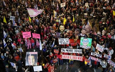 Des manifestants brandissent des pancartes et scandent des slogans lors d'une manifestation appelant à la libération des otages détenus à Gaza par  devant le ministère de la Défense à Tel Aviv, le 8 février 2025. (Crédit : Jack Guez/AFP)