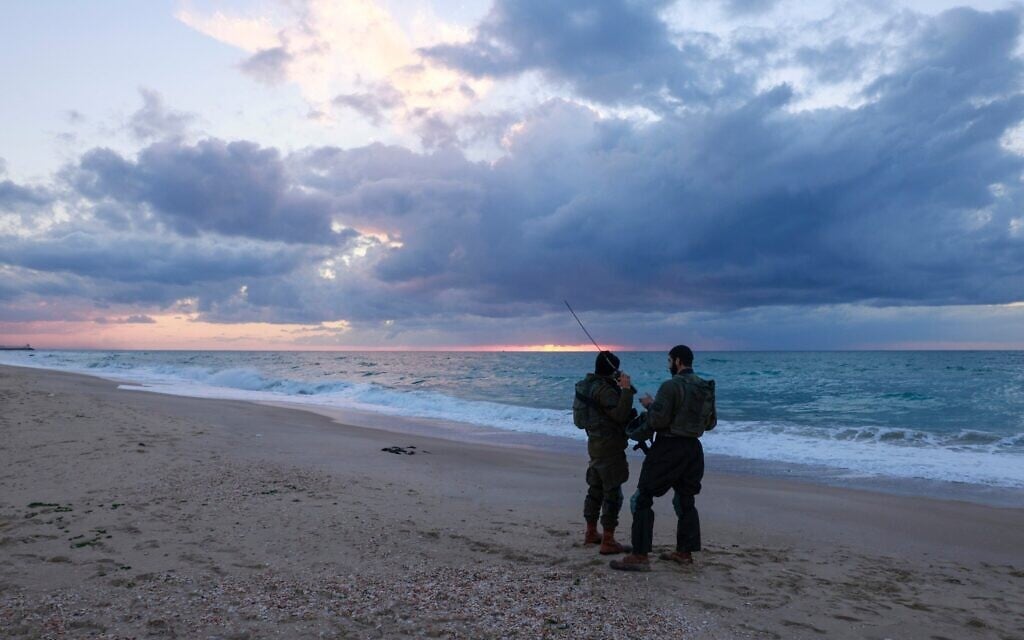 Des soldats israéliens patrouillent sur la plage de Zikim, près de la frontière avec le nord de Gaza, le 12 février 2025. (Crédit : Menahem KAHANA / AFP)