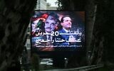 La circulation se déroule derrière un panneau géant portant le portrait de l'ancien Premier ministre libanais Rafic Hariri (à gauche) et de son fils Saad Hariri, également ancien Premier ministre, dans le centre de Beyrouth, le 13 février 2025, à la veille du 20e anniversaire de l'assassinat de Rafic Hariri. (Photo de Joseph EID / AFP)
