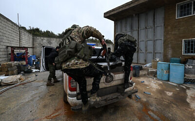 Des membres des forces de sécurité syriennes sautant à l'arrière d'une camionnette dans une ancienne usine de drogue située dans un bâtiment abandonné près du village de Hawik, dans la campagne de Qousseir, en Syrie, le 12 février 2025. (Crédit : Louai Beshara/AFP)