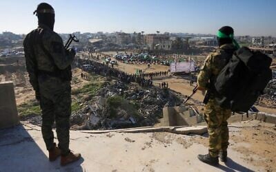 Un homme armé du Hamas surveille la zone depuis un bâtiment en hauteur peu de temps avant la remise d'otages israéliens à une équipe de la Croix-Rouge à Khan Younès, dans le sud de la bande de Gaza, le 15 février 2025. (Photo de Bashar TALEB / AFP)