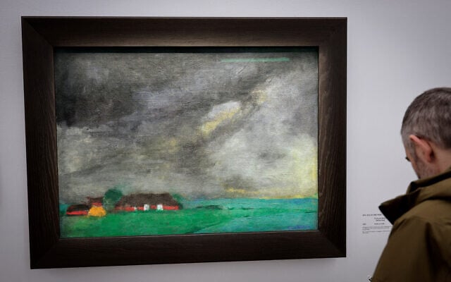 Un visiteur regarde une peinture intitulée "Ferme de Hulltoft"  de l'artiste allemand Emil Nolde, présentée lors de l'avant-première de l'exposition" L'Art Dégénéré" au Musée Picasso à Paris, le 12 février 2025. (Crédit : STEPHANE DE SAKUTIN / AFP)