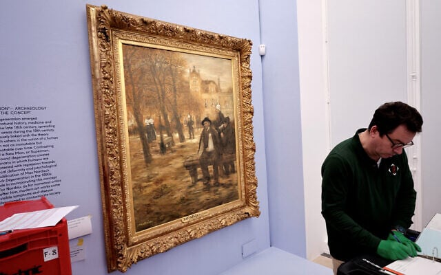 Un technicien vérifie une peinture de l'artiste français Jean-François Raffaelli, présentée lors de l'avant-première de l'exposition "L'Art dégénéré" au musée Picasso à Paris, le 12 février 2025. (Crédit : STEPHANE DE SAKUTIN / AFP)