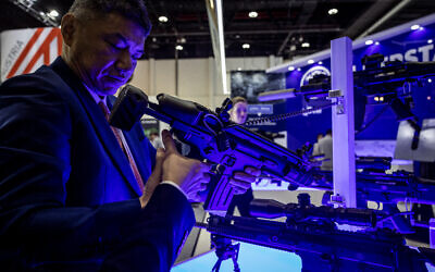 Un visiteur observe une arme lors de l'exposition internationale de défense Idex 2025, le 17 février 2025, à Abu Dhabi. (Photo FADEL SENNA / AFP)
