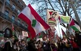 Un manifestant brandit le drapeau libanais et un drapeau sur lequel est écrit en français « Libérez Georges Abdallah » lors d'un rassemblement à Toulouse pour exiger la libération de l'assassin pro-palestinien libanais Georges Ibrahim Abdallah, le 19 février 2025. (Crédit : Matthieu RONDEL / AFP)