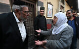 Une femme musulmane s'adresse au rabbin syrien Youssef Hamra, basé aux États-Unis, lors de sa première visite depuis le début des années 1990 à Damas, devant la synagogue Ifrange dans le quartier juif du district de Bab Sharqi, dans la capitale syrienne, le 19 février 2025. (Crédit : LOUAI BESHARA / AFP)