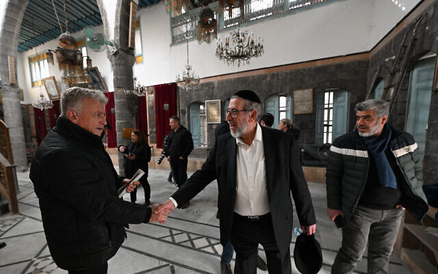 Le rabbin syrien Youssef Hamra (au centre), basé aux États-Unis, serre la main d'un autre juif après la première prière collective depuis 1992, organisée à la synagogue Ifrange dans le quartier juif du district de Bab Sharqi à Damas, le 19 février 2025. (Crédit : Louai Beshara/AFP)