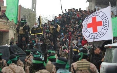 Une foule regardant des terroristes armés du Hamas remettre les corps de quatre otages israéliens à la Croix-Rouge, à Khan Younès, dans le sud de Gaza, le 20 février 2025. (Crédit : Eyad Baba/AFP)