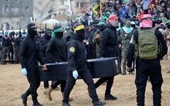 Des terroristes palestiniens transportant l'un des cercueils supposé contenir le corps d'un otages israélien à la Croix Rouge, à Khan Younès, dans la bande de Gaza, le 20 février 2025. (Crédit : Eyad Baba/AFP)