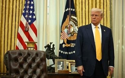 Le président américain Donald Trump derrière son pupitre lors de la cérémonie d'assermentation du secrétaire américain au Commerce Howard Lutnick, dans le Bureau ovale de la Maison Blanche, à Washington, le 21 février 2025. (Crédit : Jim Watson/AFP)