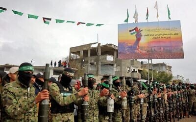 Des terroristes du Hamas lourdement armés se tiennent debout, alignés, sur lex lieux d'une remise d'otages israéliens à Rafah, dans le sud de la bande de Gaza, le 22 février 2025. (Omar AL-QATTAA / AFP)