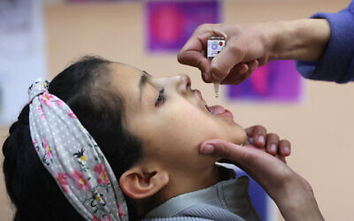 Un élève palestinien reçoit un vaccin contre la polio le premier jour de cours dans une école de la ville de Gaza, le 23 février 2025, dans le cadre d'une campagne de vaccination contre la polio. (Photo par Omar AL-QATTAA / AFP)