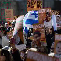 Des manifestants tiennent des pancartes sur lesquelles on peut lire « impardonnable », « injustifiable » et « innommable » alors qu'ils se rassemblent devant le Mémorial de la Shoah pour rendre hommage aux otages décédés dont les corps ont été restitués à Israël par le Hamas, un hommage appelé par le Conseil représentatif des institutions juives de France (CRIF) dans le centre de Lyon, dans le sud-est de la France, le 23 février 2025. (Photo JEAN-PHILIPPE KSIAZEK / AFP)