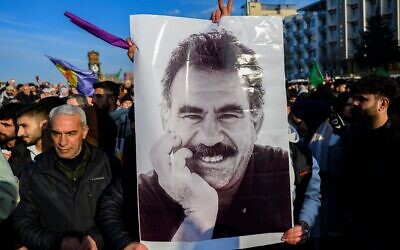 Des partisans affichent une affiche représentant le dirigeant emprisonné du Parti des travailleurs du Kurdistan (PKK), Abdullah Öcalan, 75 ans, après qu'il a appelé le Parti des travailleurs du Kurdistan (PKK) à désarmer et à se dissoudre à Diyarbakir, dans le sud-est de la Turquie, le 27 février 2025. (Crédit 
 : Yasin Akgul / AFP)