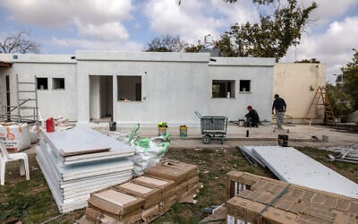 Des ouvriers du bâtiment rénovent une maison endommagée lors des attentats du 7 octobre 2023 par des terroristes palestiniens du Hamas, dans le kibboutz Nirim, le 16 février 2025. (Crédit : Menahem Kahana / AFP)